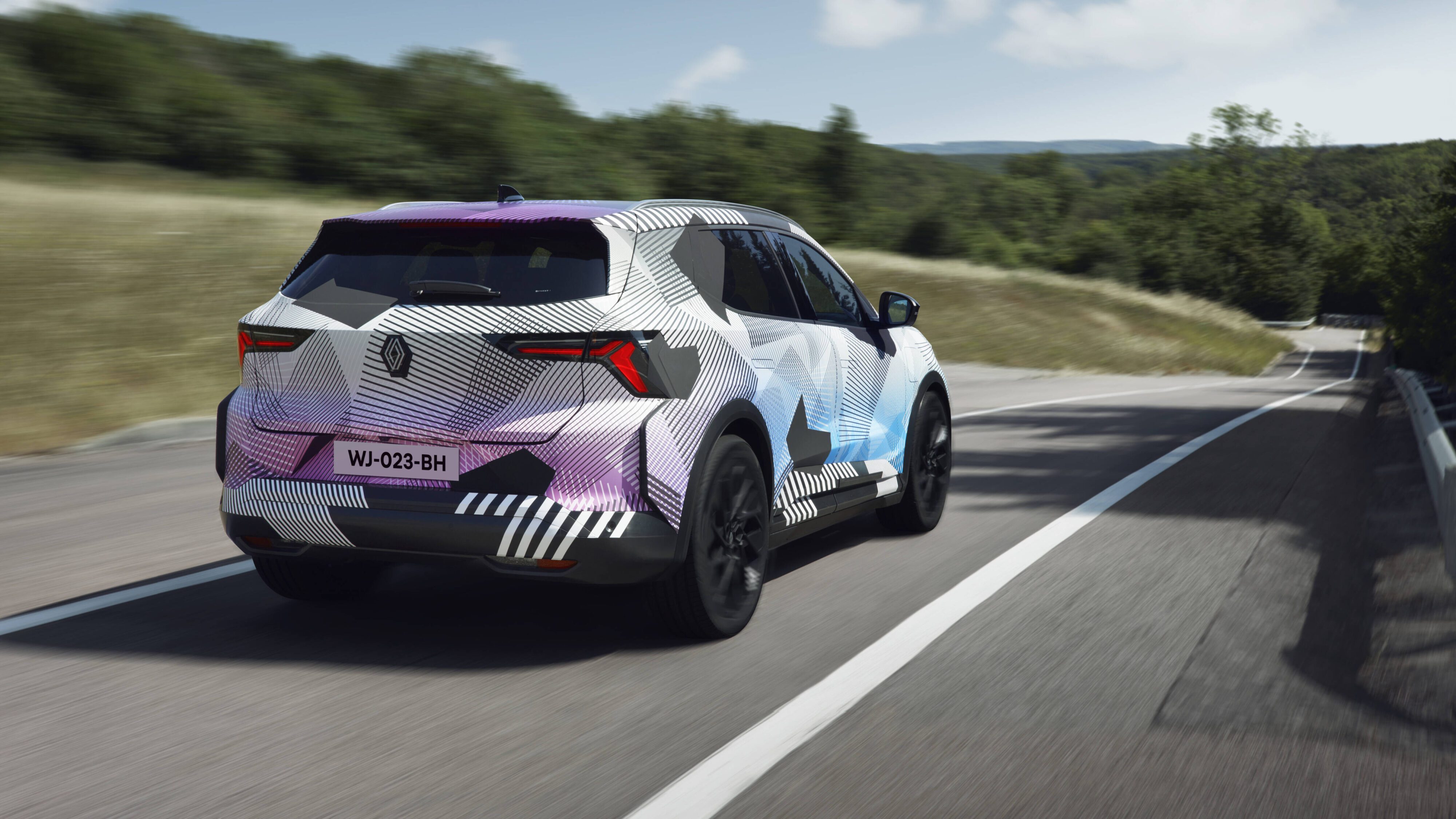Motion shot of the rear three quarters of a camouflaged Renault Scenic E-Tech electric SUV