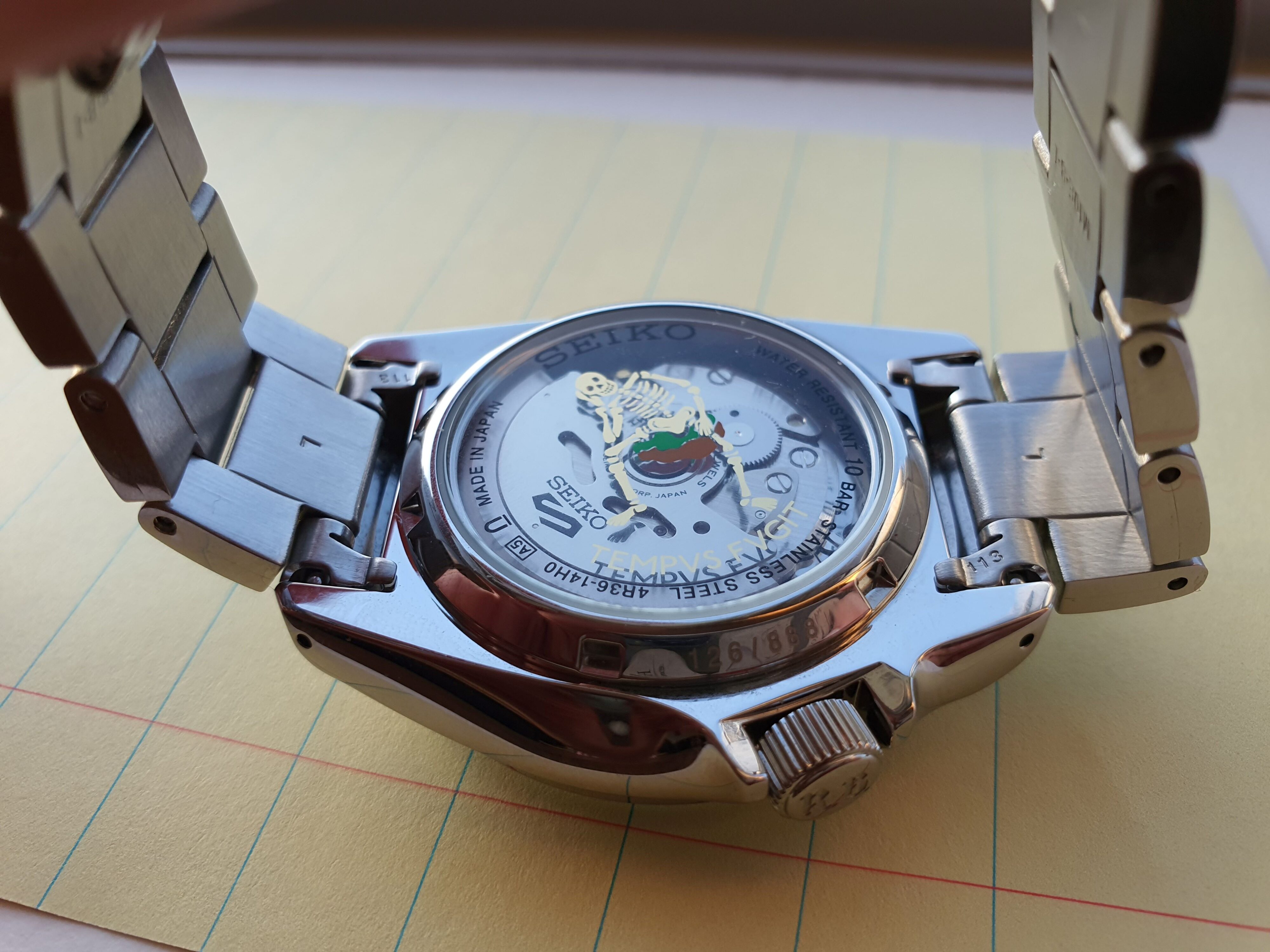 Transparent caseback of the Seiko 5 x Rowing Blazers wristwatch showing the Seiko 4R36A automatic movement and Rowing Blazers' 'TEMPUS FUGIT' emblem