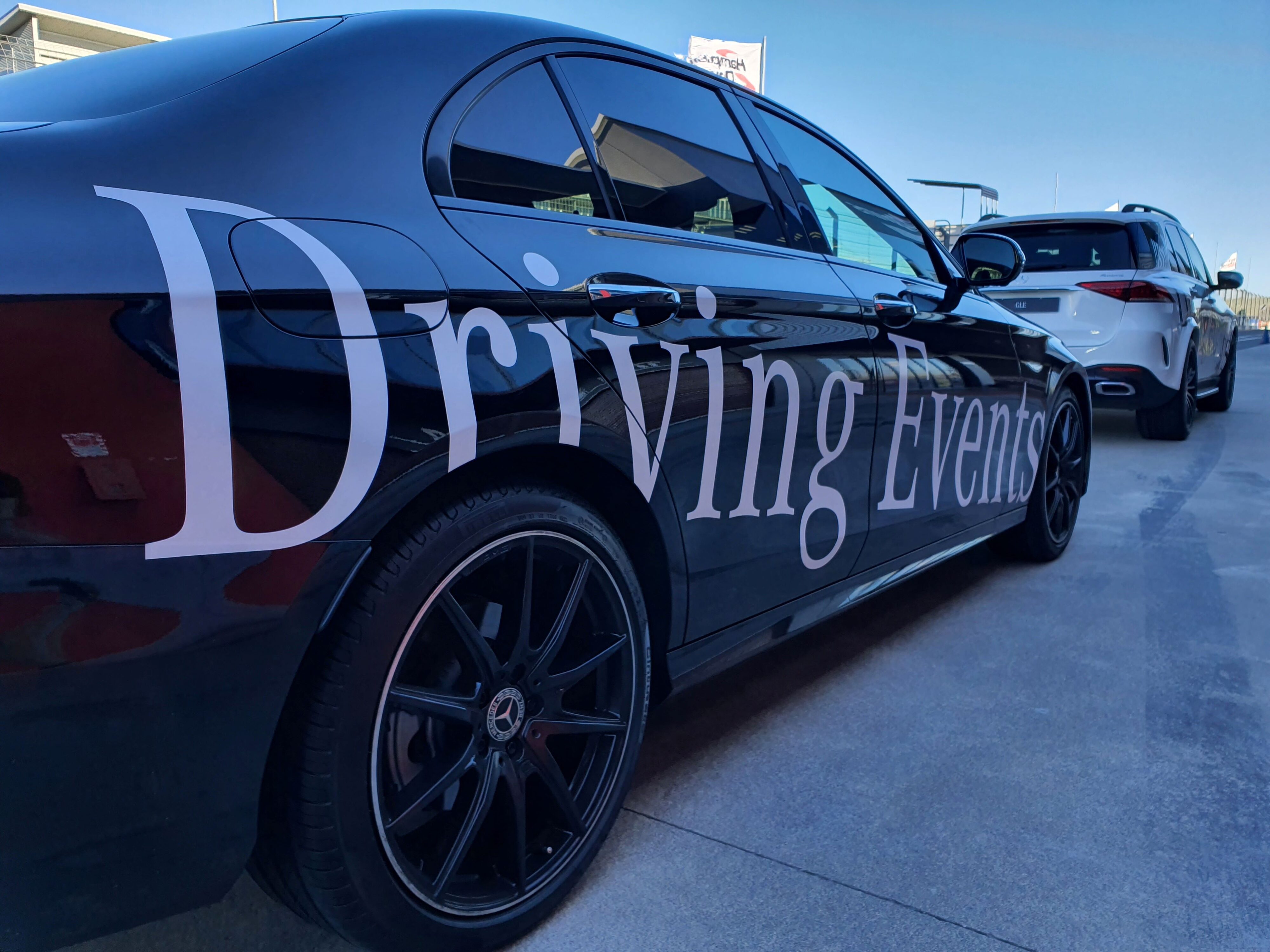 A close-up of the 'Driving Events' livery on the side of a Mercedes-Benz E-Class sedan.