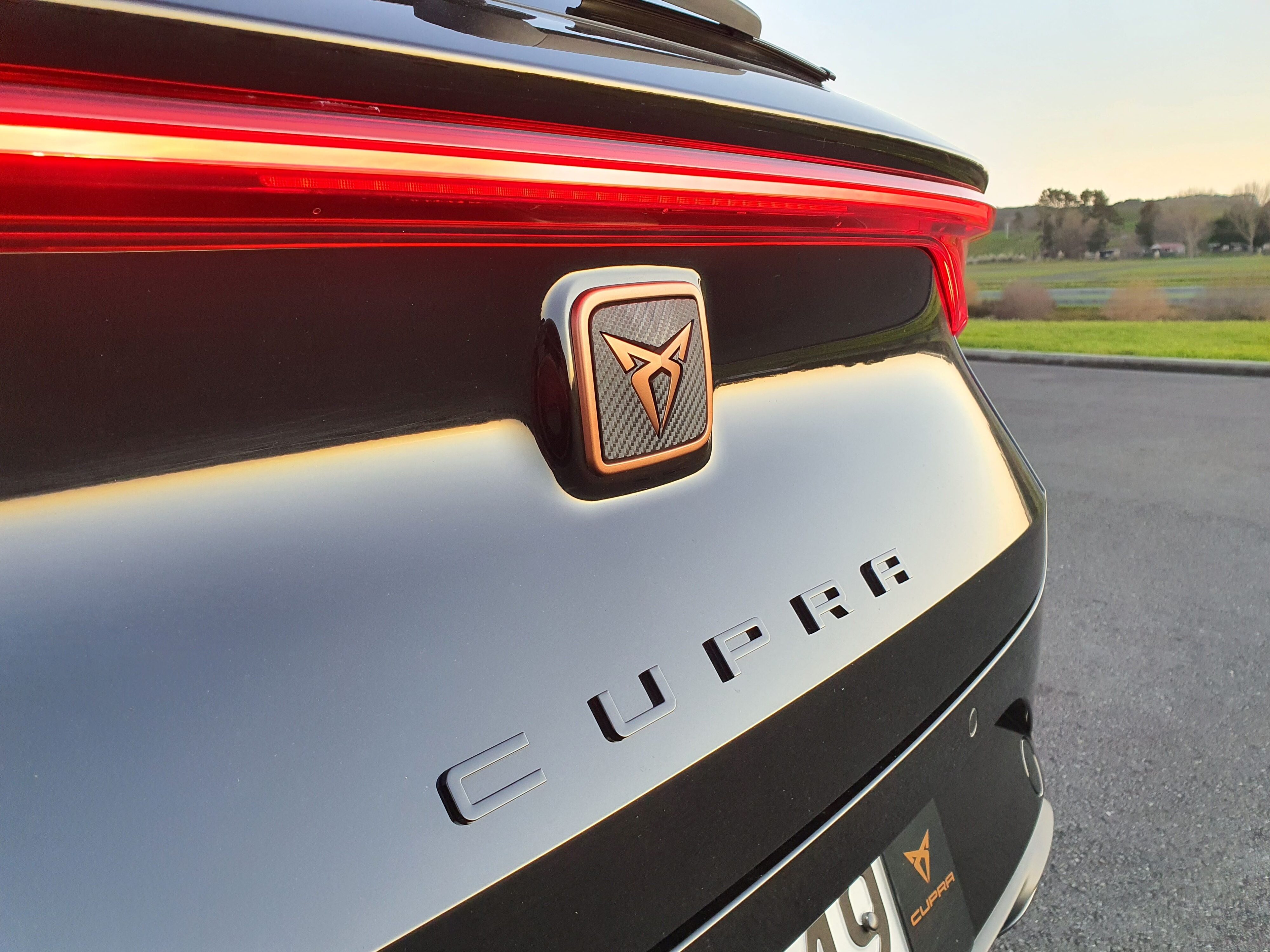 Photograph of a Cupra badge on the rear of a 2023 Cupra Leon V Sports Tourer in black.
