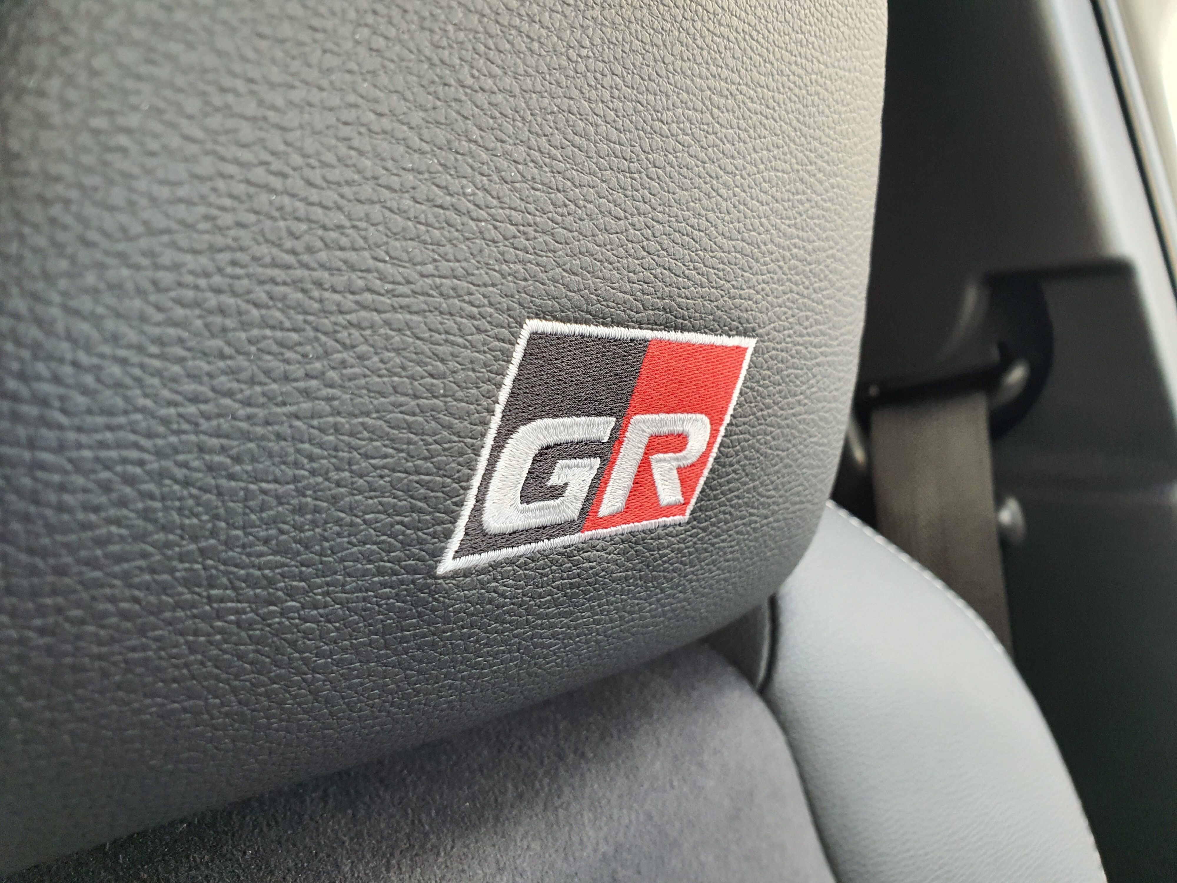A close-up of the GR badge on the seat headrests of a 2023 Toyota Yaris Cross GR Sport.