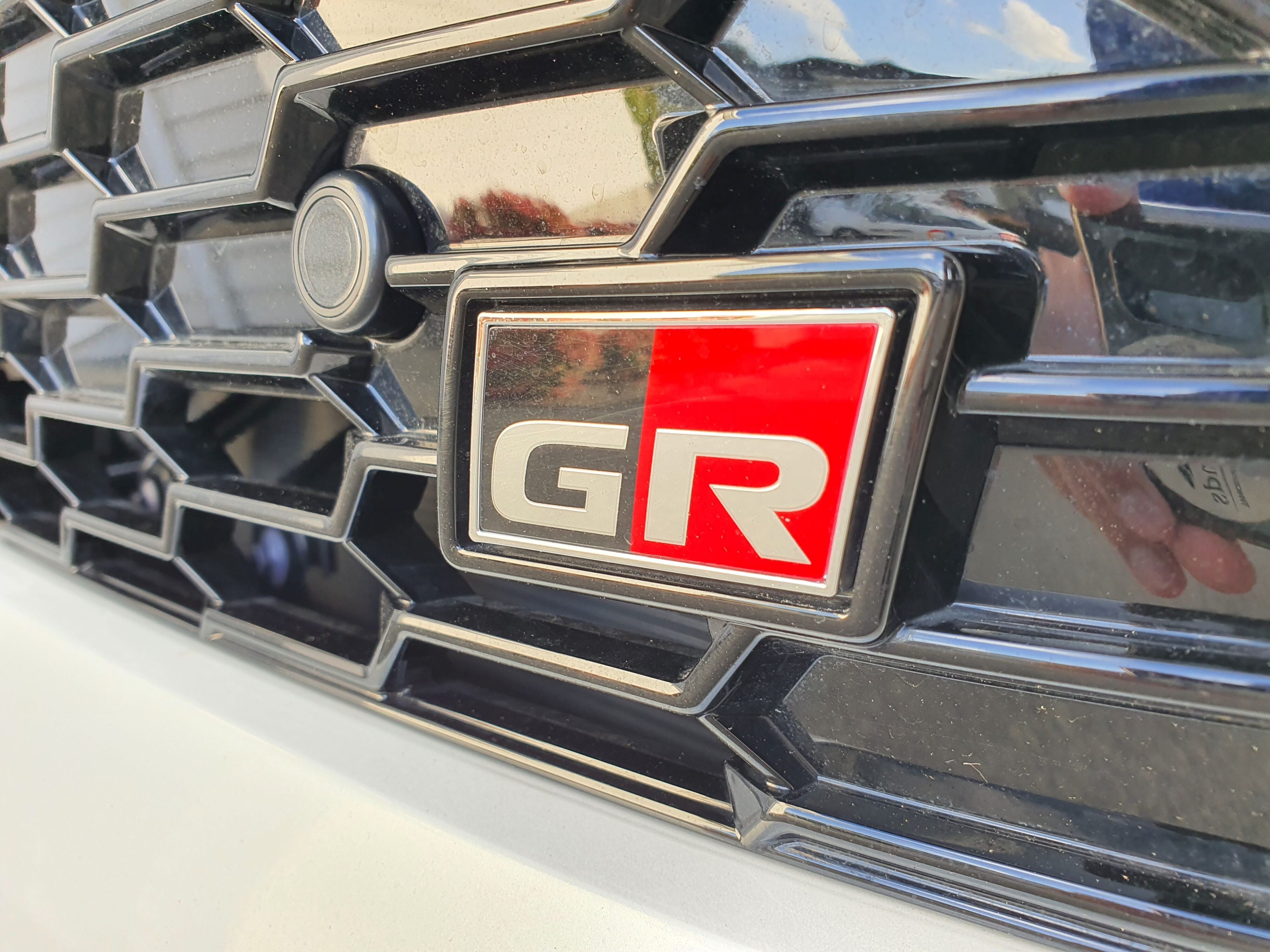A close-up of the GR badge on the front of a 2023 Toyota Yaris Cross GR Sport.