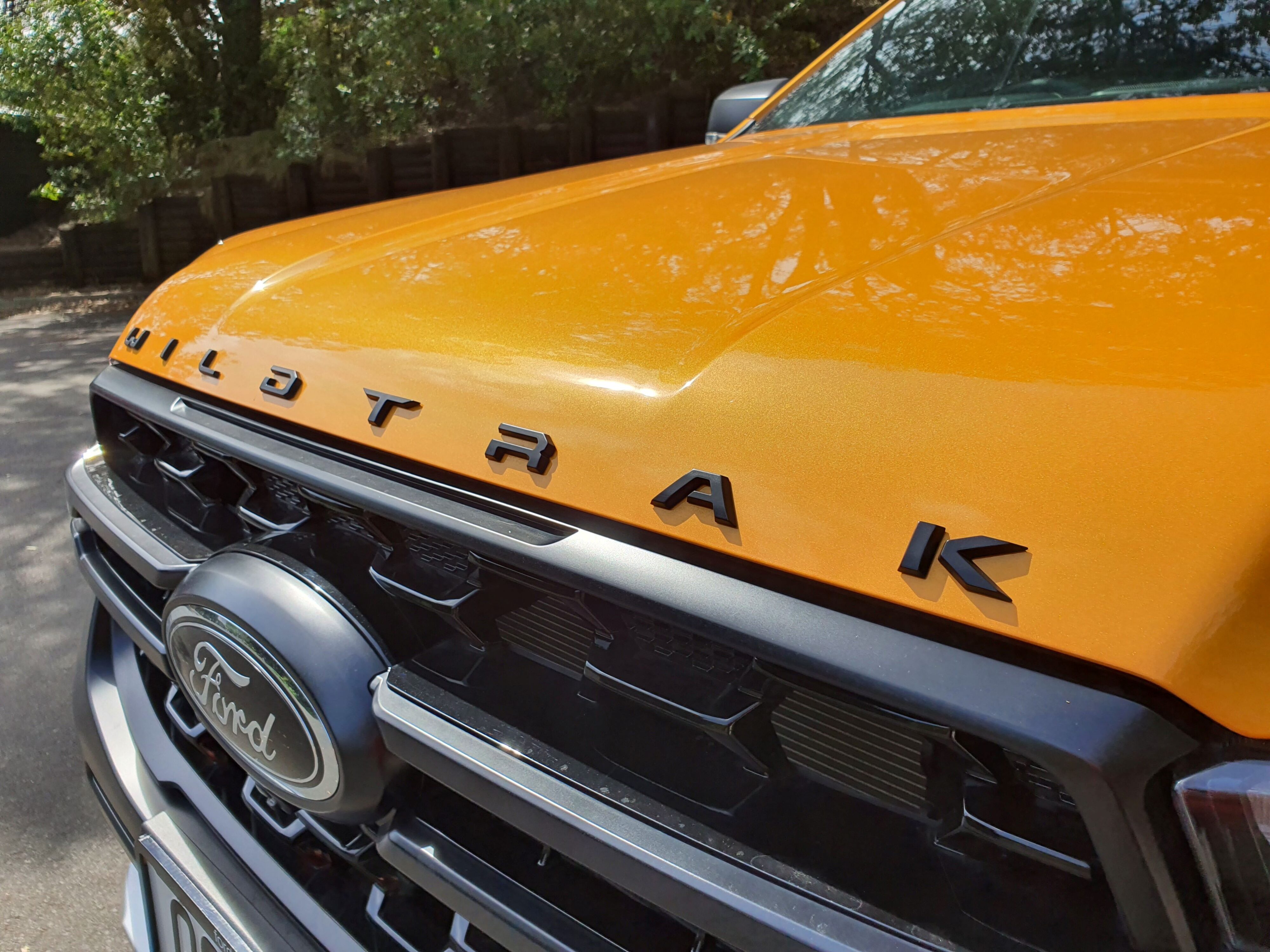Black Wildtrak badging on the nose of a 2023 Ford Ranger Wildtrak X in Cyber Orange.