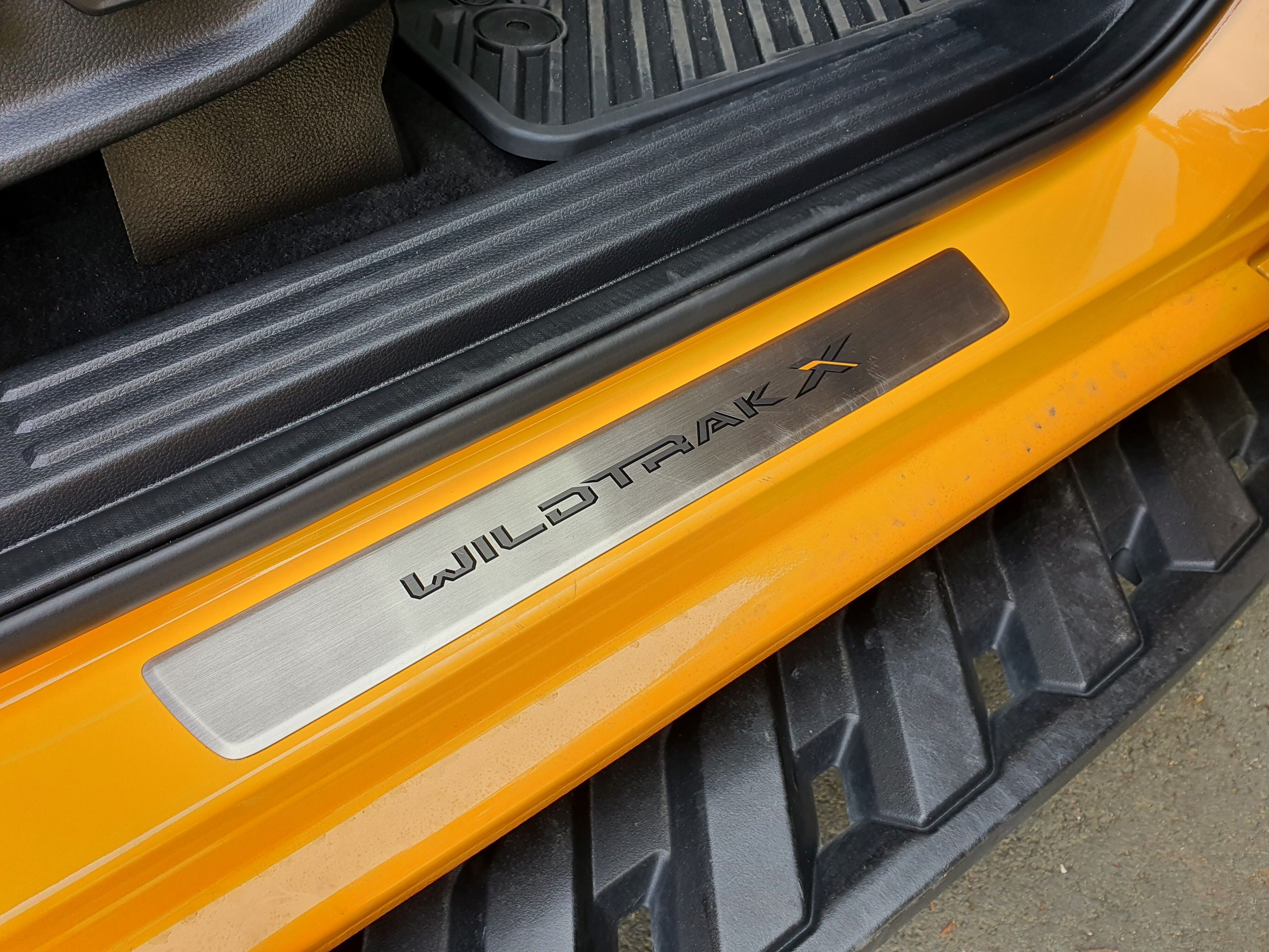 Wildtrak X treadplates on the interior of a 2023 Ford Ranger Wildtrak X in Cyber Orange.