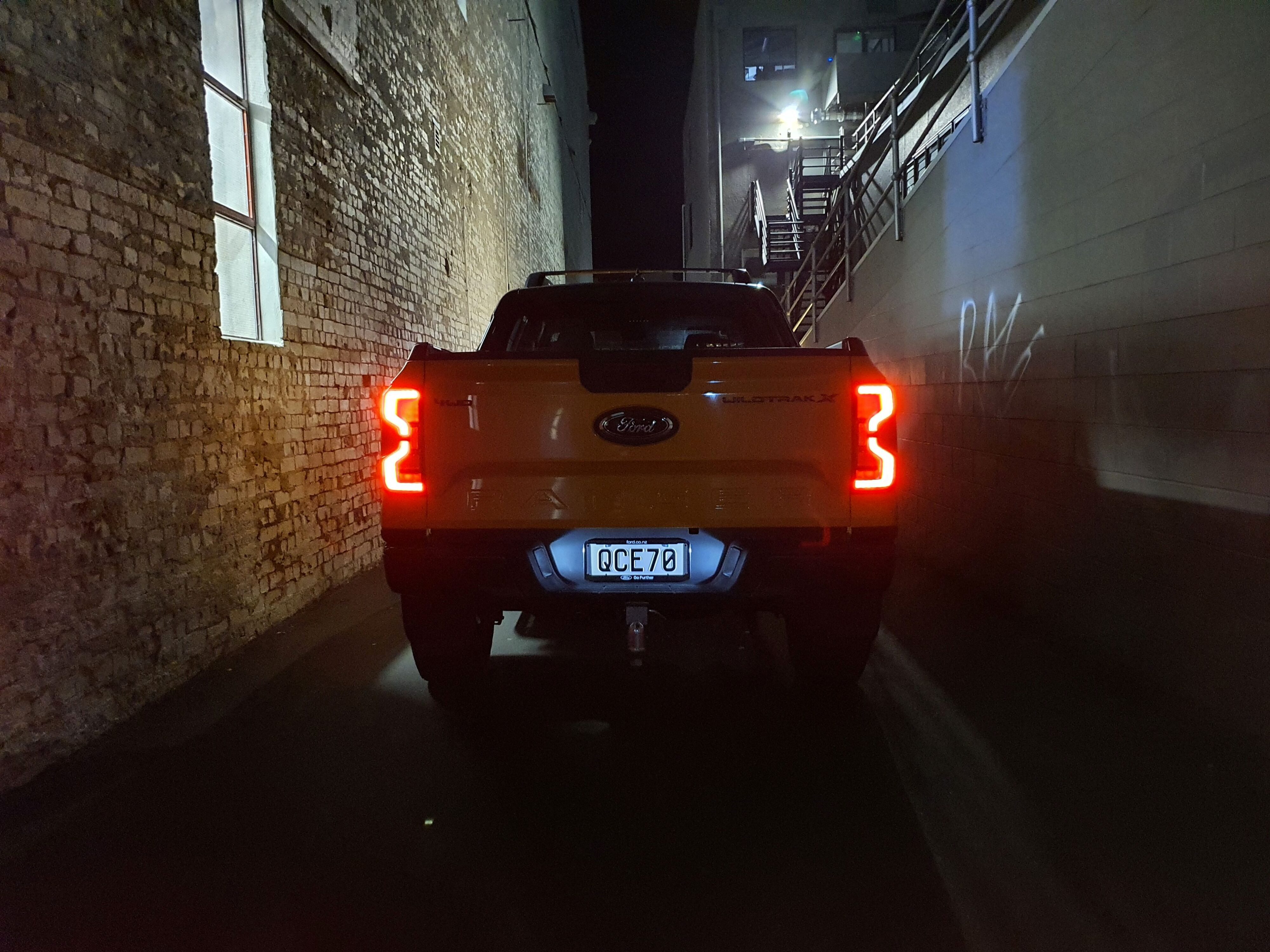 Rear view of a 2023 Ford Ranger Wildtrak X at night with the LED taillights on.