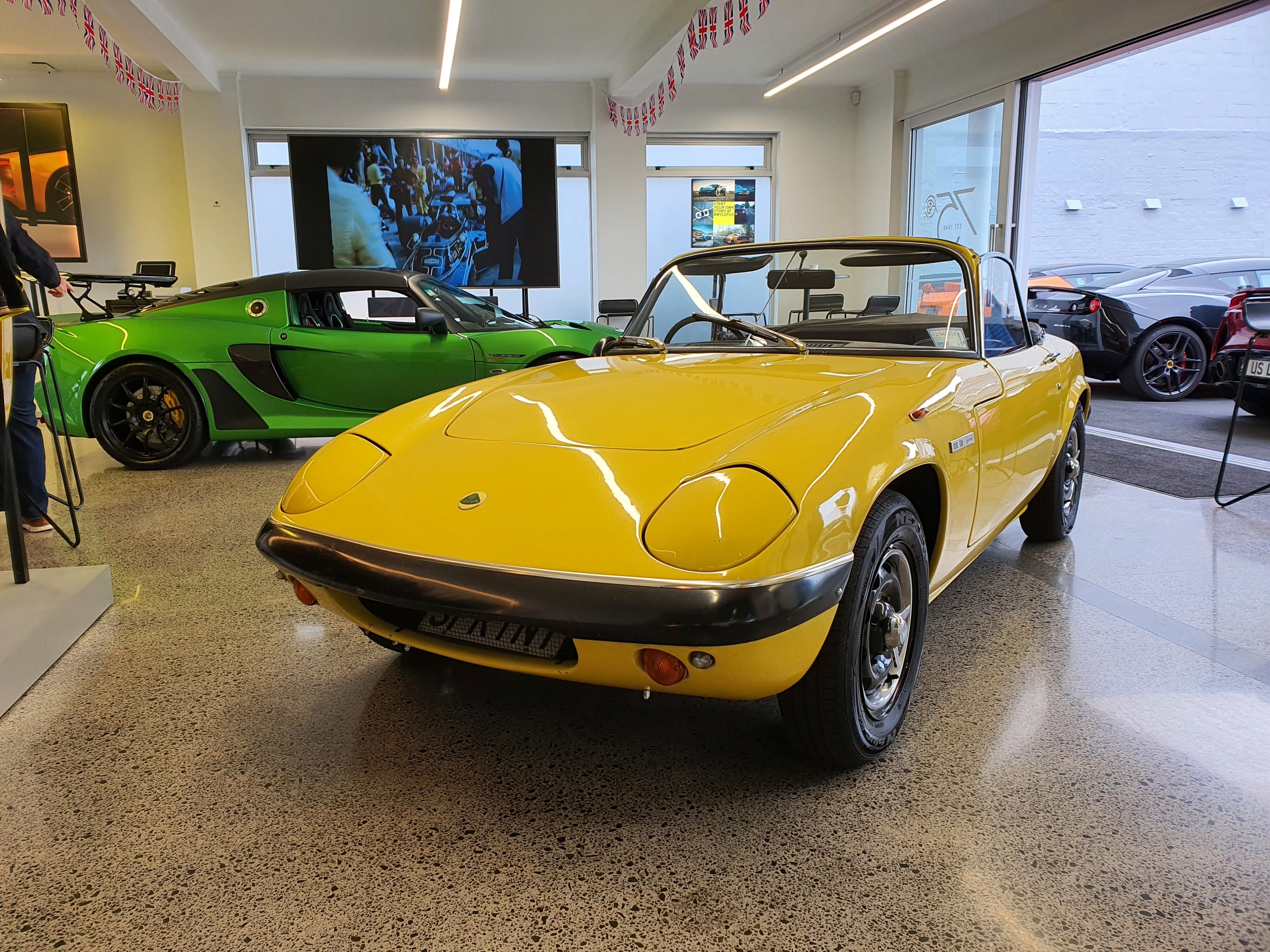 A shot of a Lotus Elan in yellow and a Lotus Exige Final Edition 430 Cup in Green at Lotus Cars Auckland.