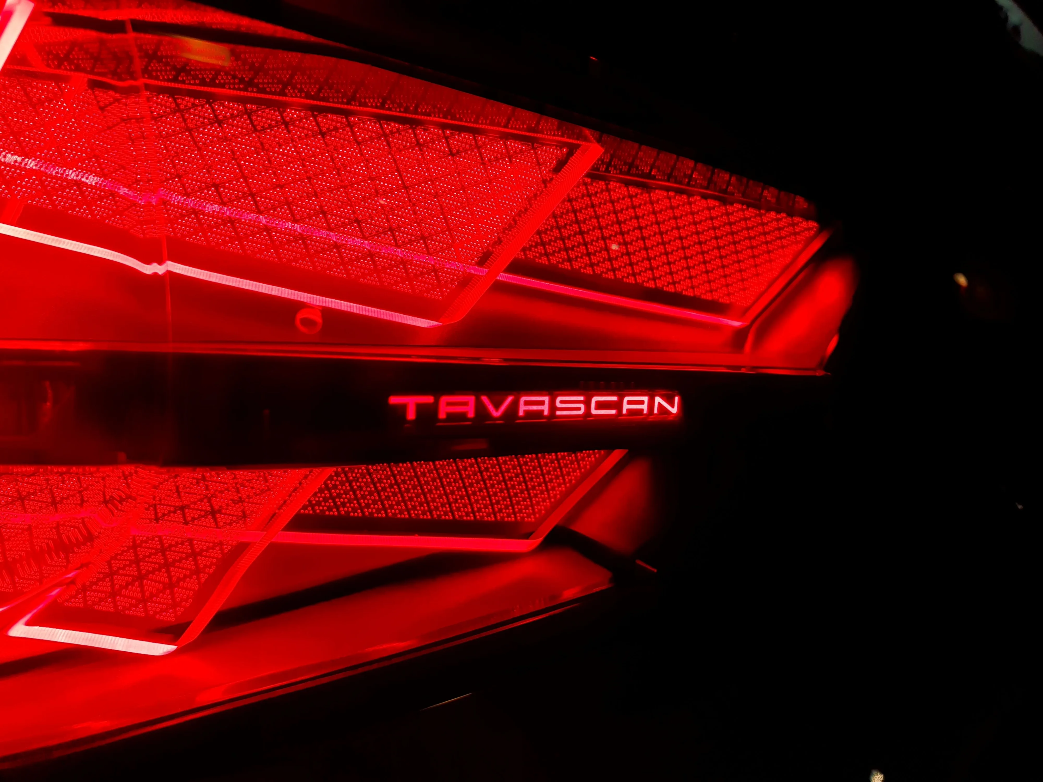 View of the Tavascan badge on the rear taillight of a 2025 Cupra Tavascan VZ in Tavascan Blue.