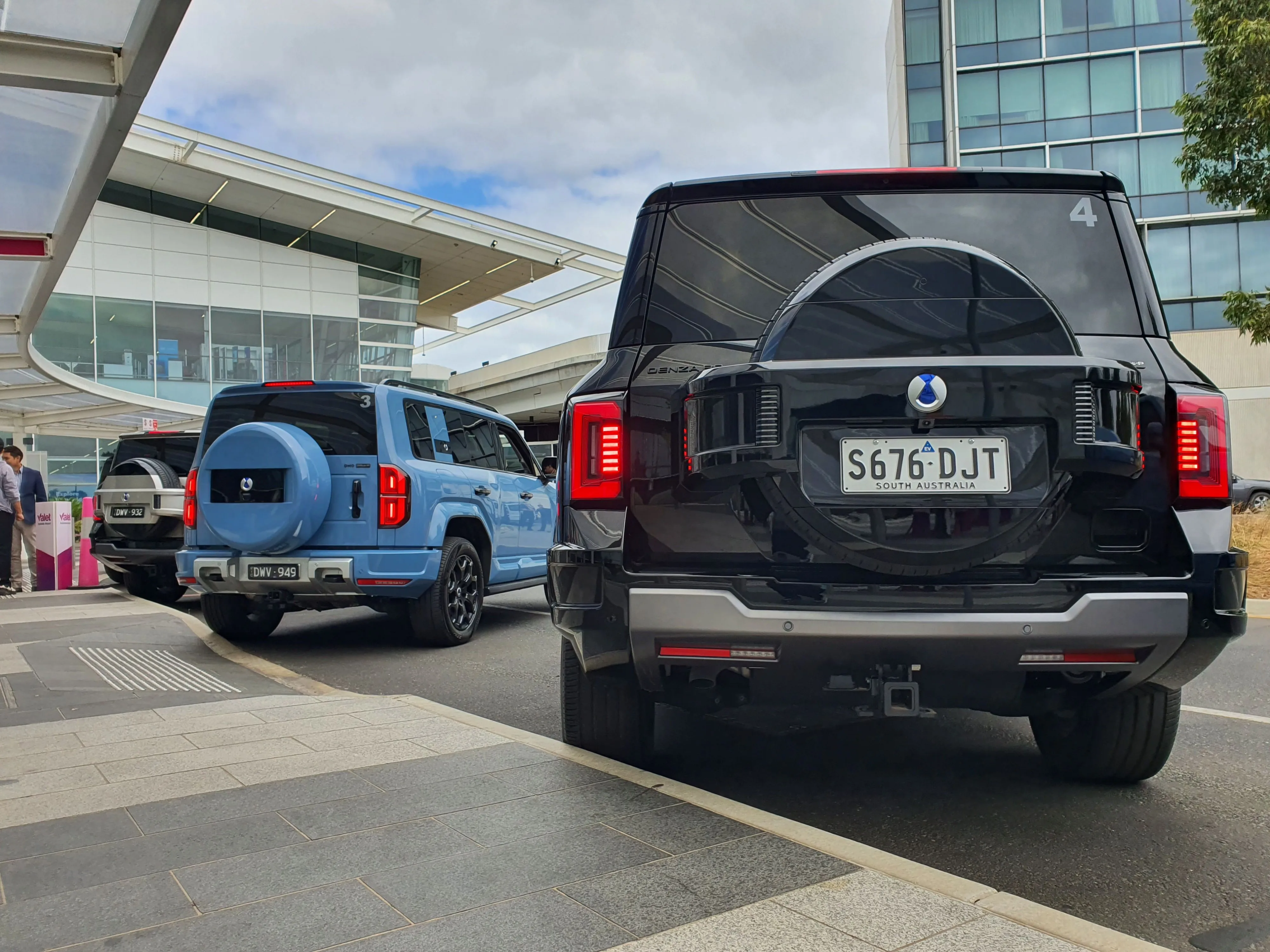 A black DENZA B8 parked alongside a blue DENZA B5 on the brand's Australia New Zealand launch.