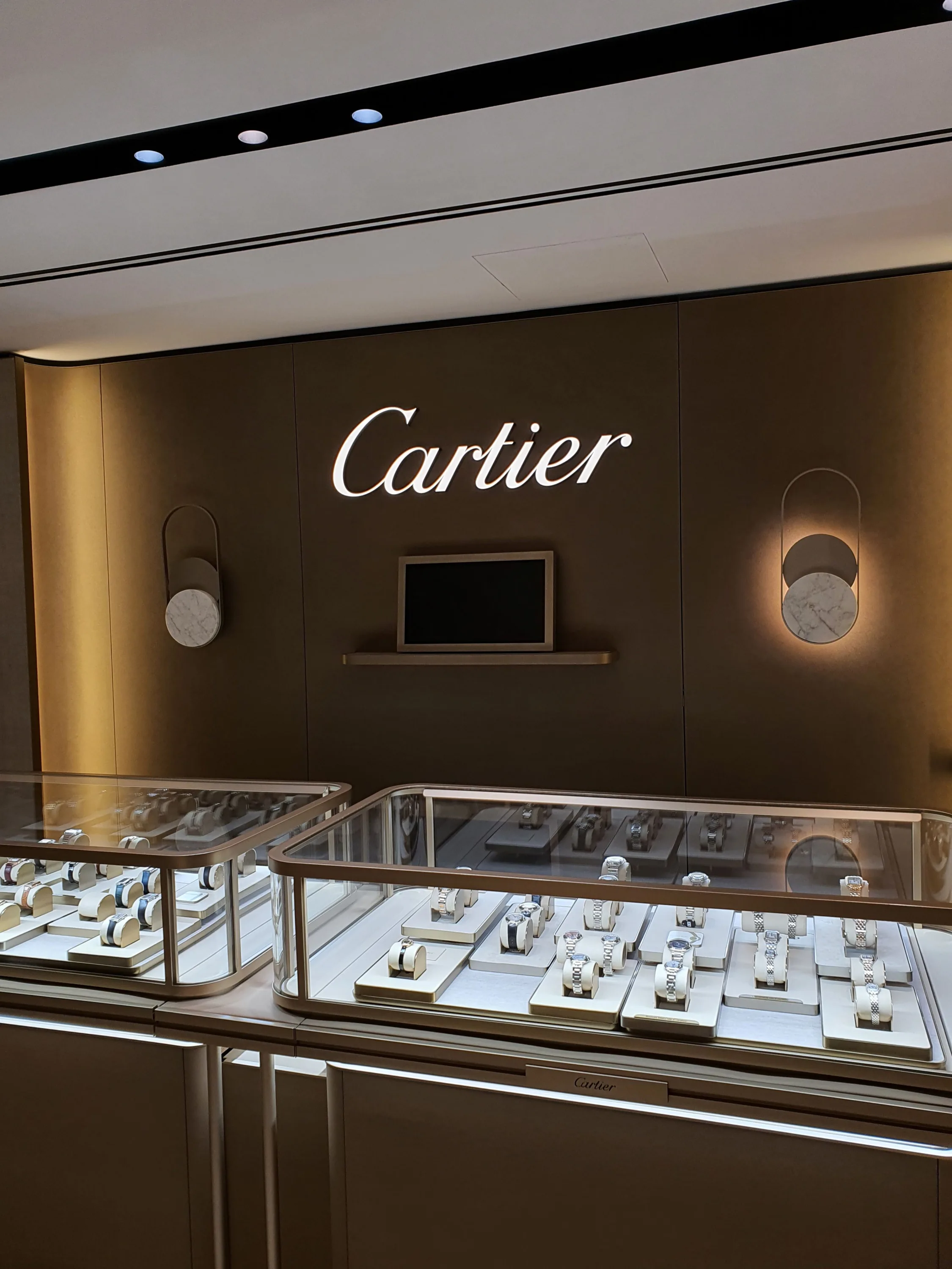 A Cartier display inside The Hour Glass Sydney, Australia featuring a glass cabinet with watches inside.