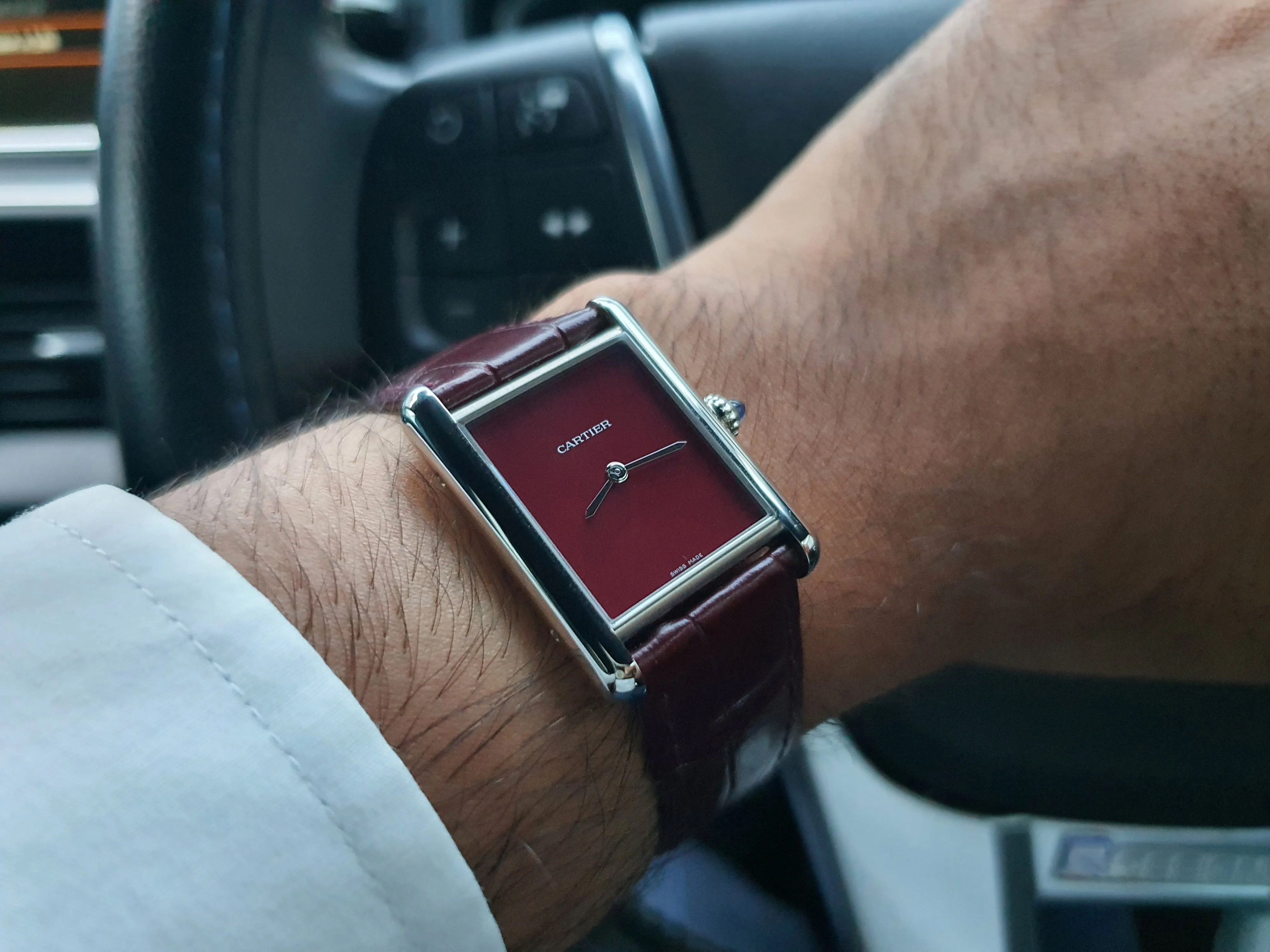 Cartier Tank in Claret (Burgundy), photographed on Matthew's left wrist.