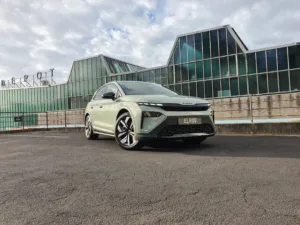 Front three quarters view of a 2026 Skoda Elroq Sportline in Timiano Green in front of an industrial building.