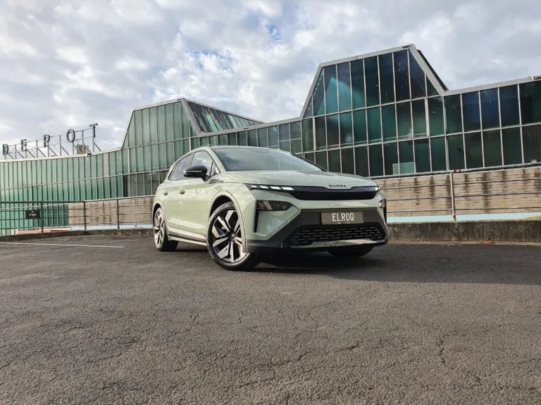 Front three quarters view of a 2026 Skoda Elroq Sportline in Timiano Green in front of an industrial building.