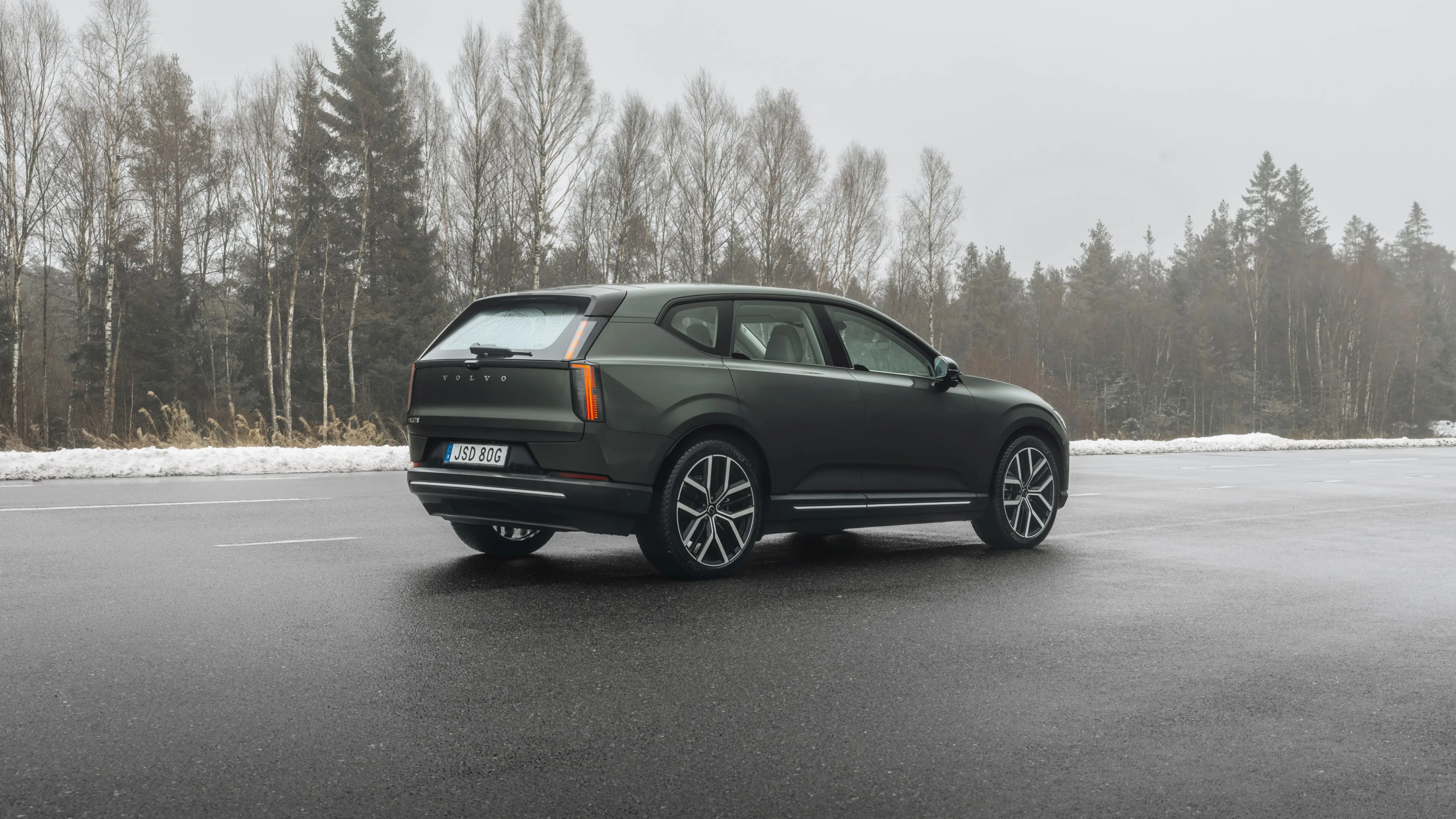 Rear three quarters view of a Volvo EX60 with a snowy/wintery scene in the background.